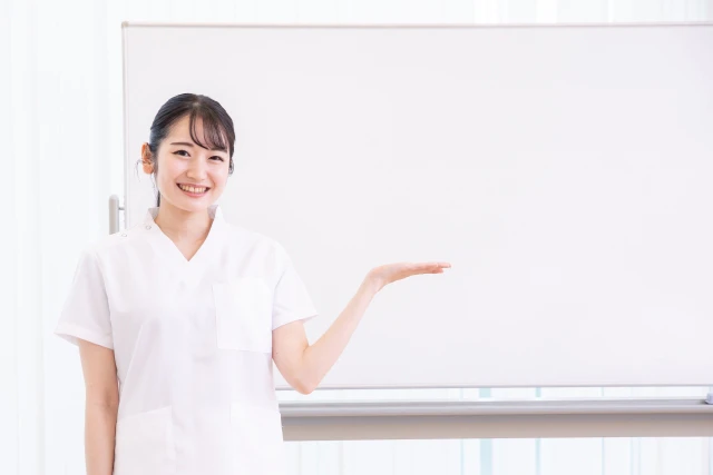 ホワイトボードを示すスタッフ