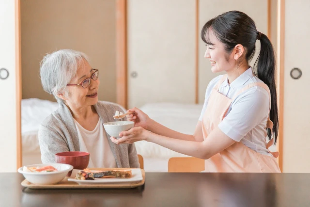 食事の介助をするスタッフと女性