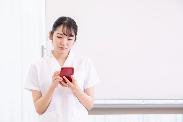 スマホを見るスタッフ