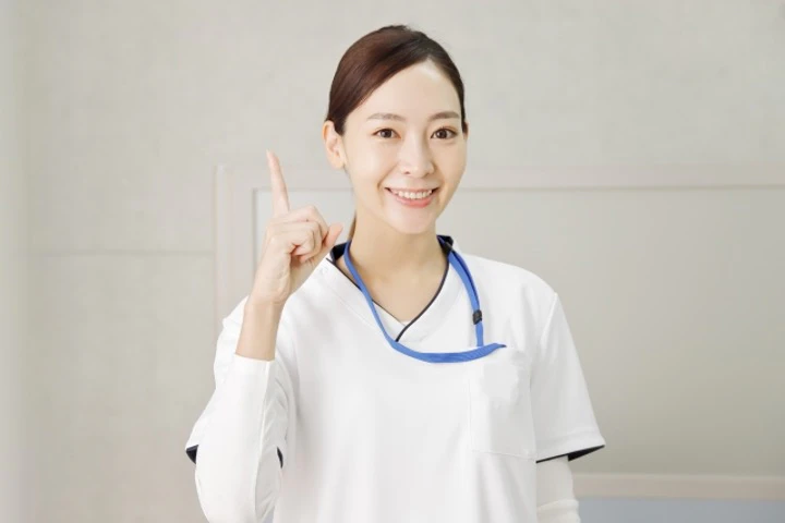 笑顔で指をさす言語聴覚士女性の写真.jpg