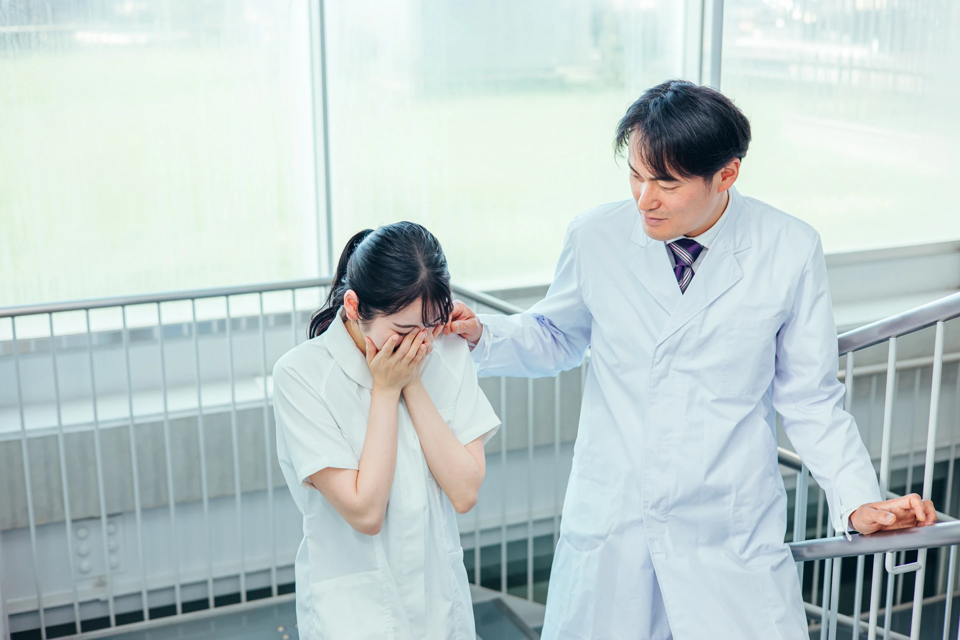 俯く看護師さんと宥めるお医者さん