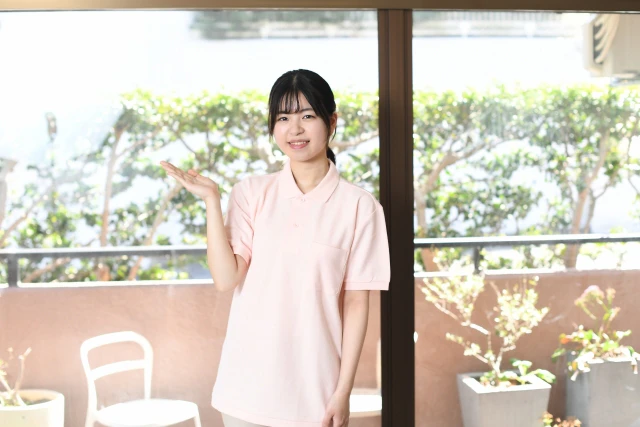 手を上にあげる女性スタッフ