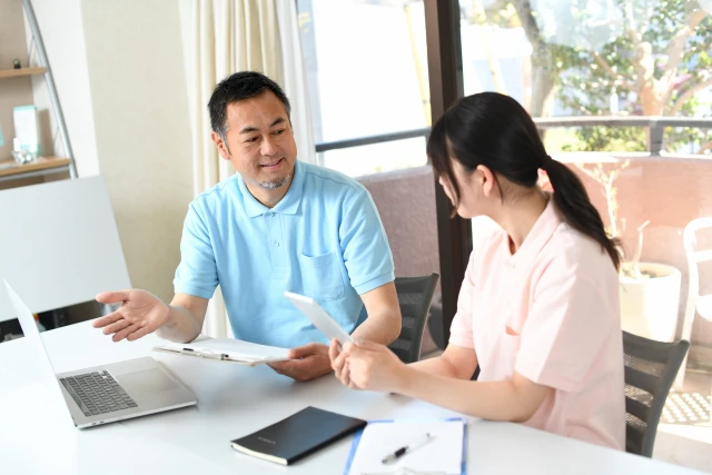 PCを見ながら話し合うスタッフ