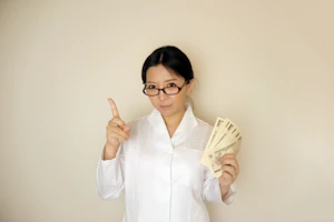白衣の看護師が札束を持って指差し
