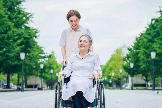 車いすの女性と談笑する療法士さん