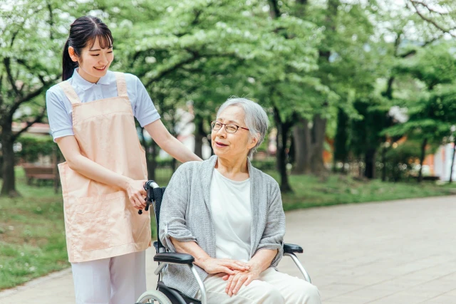 車椅子に乗った女性とスタッフ