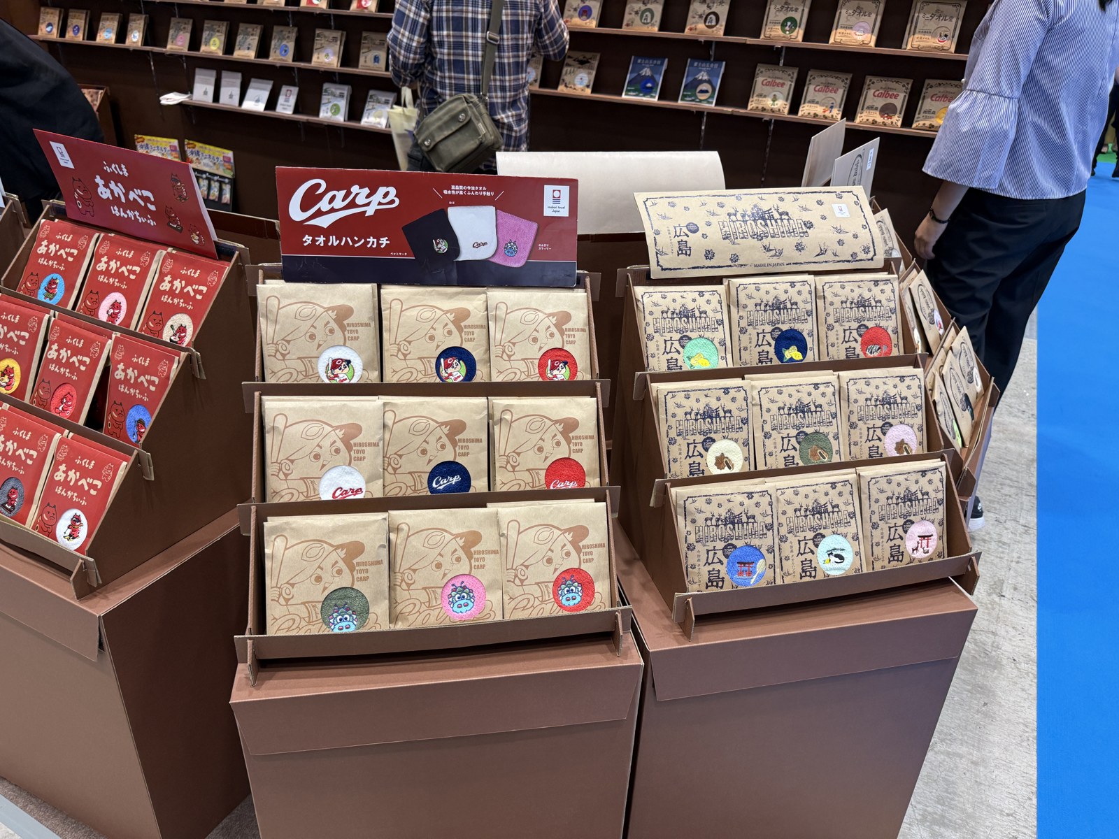 広島のモチーフや球団の絵柄を取り入れたタオルハンカチ。窓付きの台紙から色とデザインが見える展示です。
