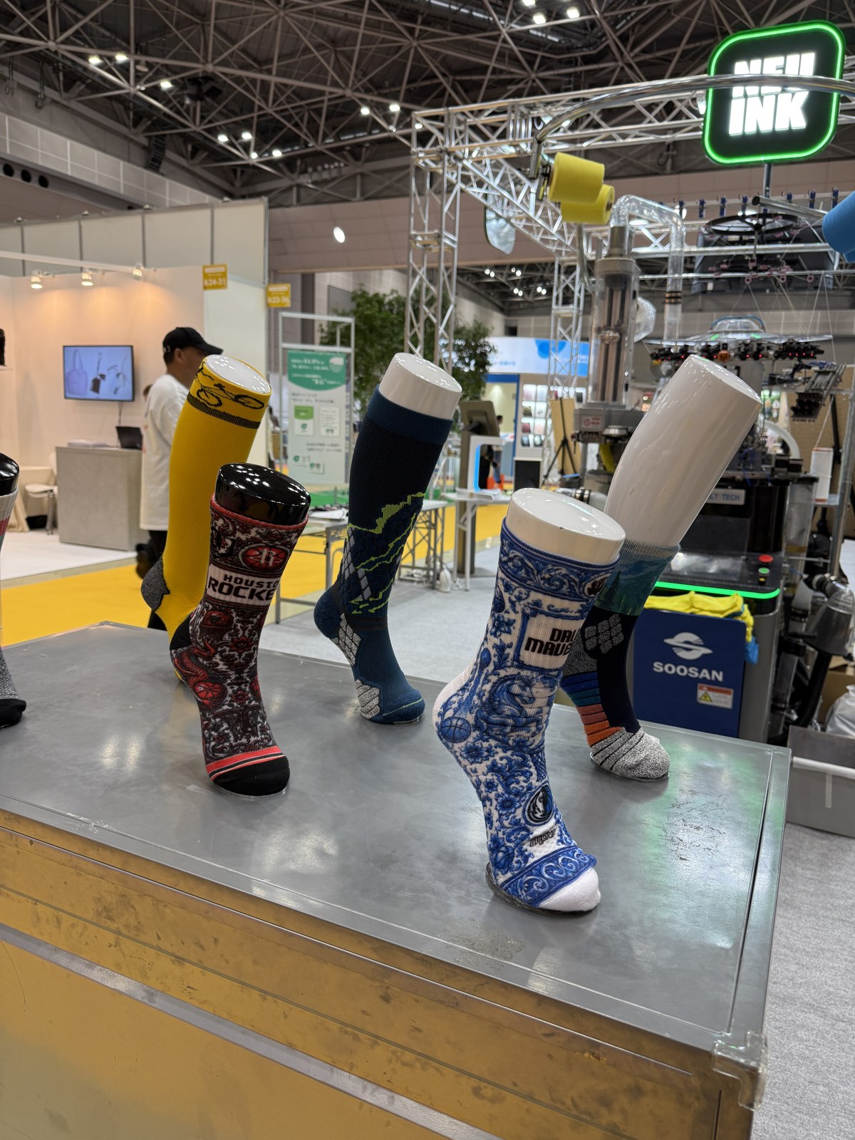 ロゴや細かな柄を取り入れた靴下のサンプル。足の形に沿ってデザインが見えるように展示されていました。