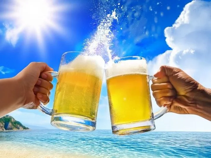 輝く空とビールを持つ手で乾杯