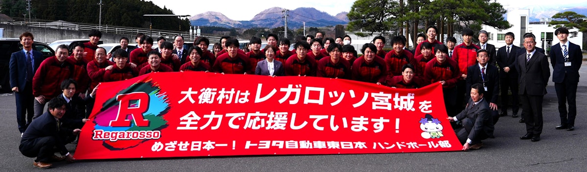 披露された応援横断幕と大衡村役場の皆様との記念撮影