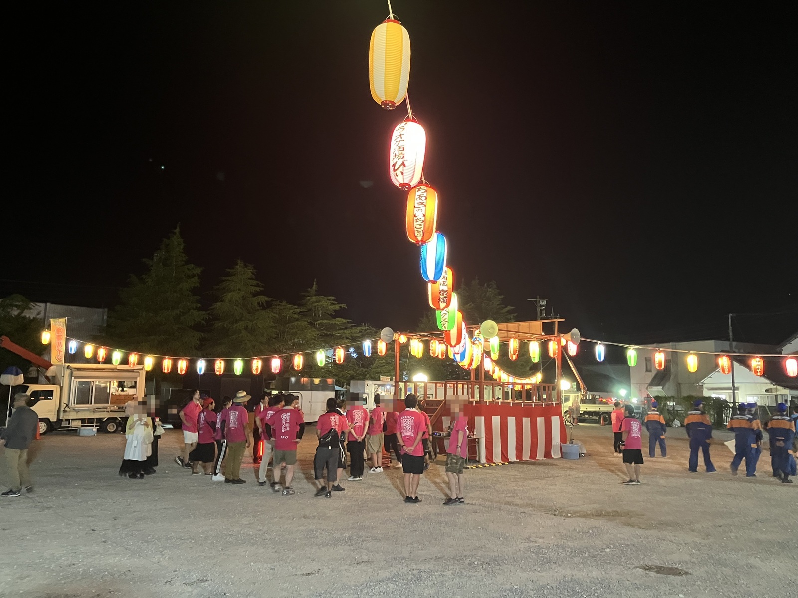 納涼盆踊り大会の会場。やぐらへ連なる提灯の明かりと、会場に集まる人たち