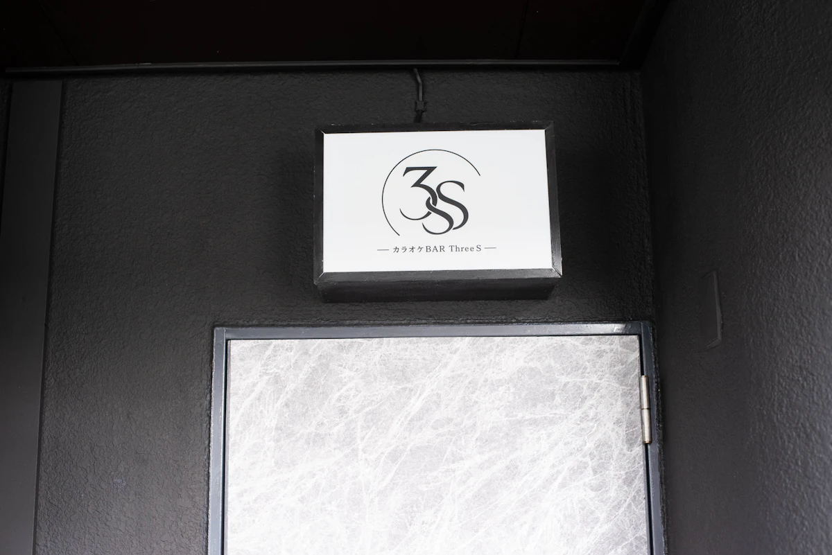 浦添市のカラオケBAR ThreeSの店舗入口上部に設置した、白地に3Sロゴを配置した完成看板