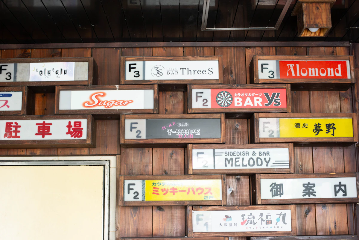 浦添市のカラオケBAR ThreeSの館内案内板。横長の白い表示面に3Sロゴと店名を配置。