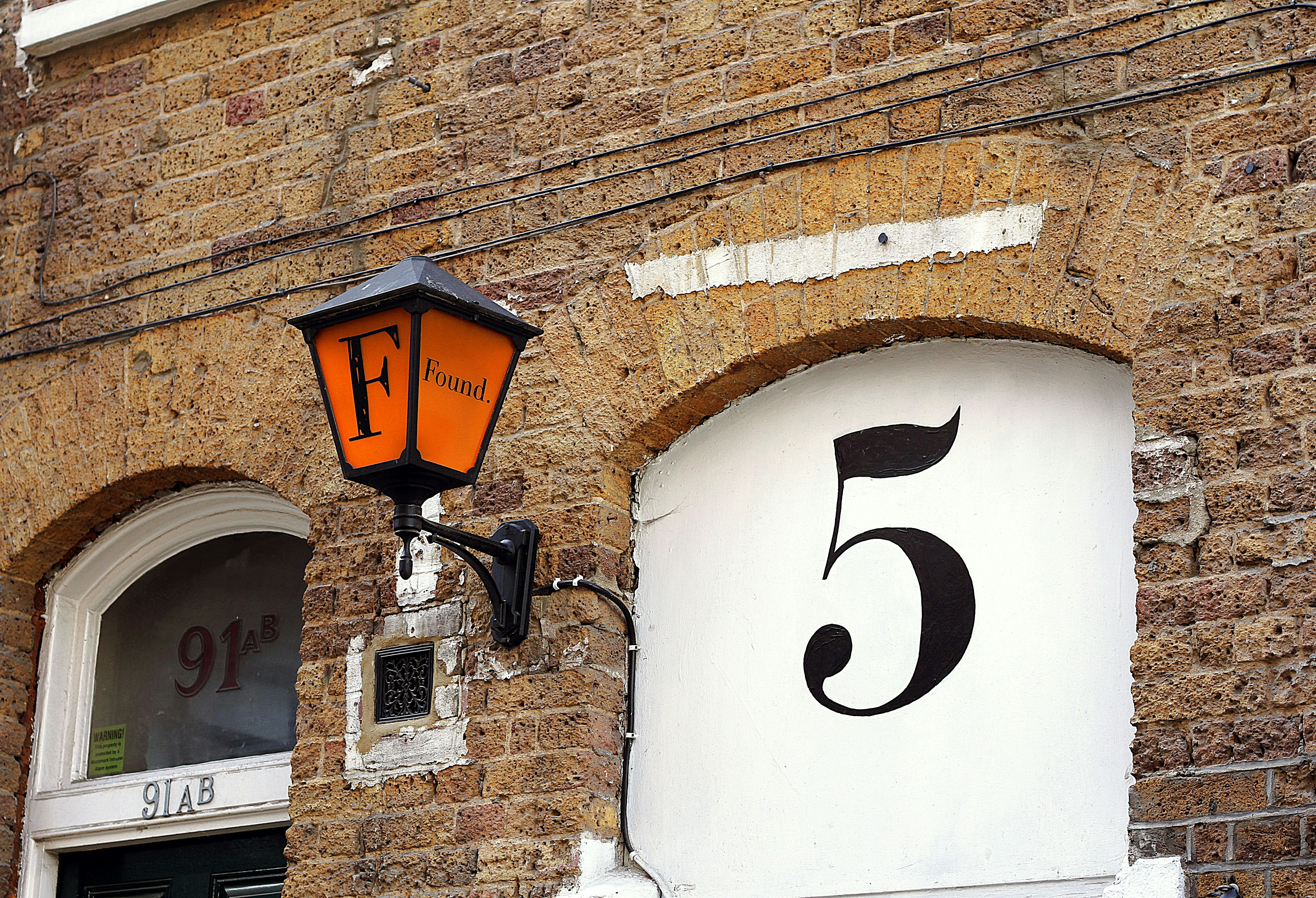 レンガ造りの建物に取り付けられた数字「5」のランプ。