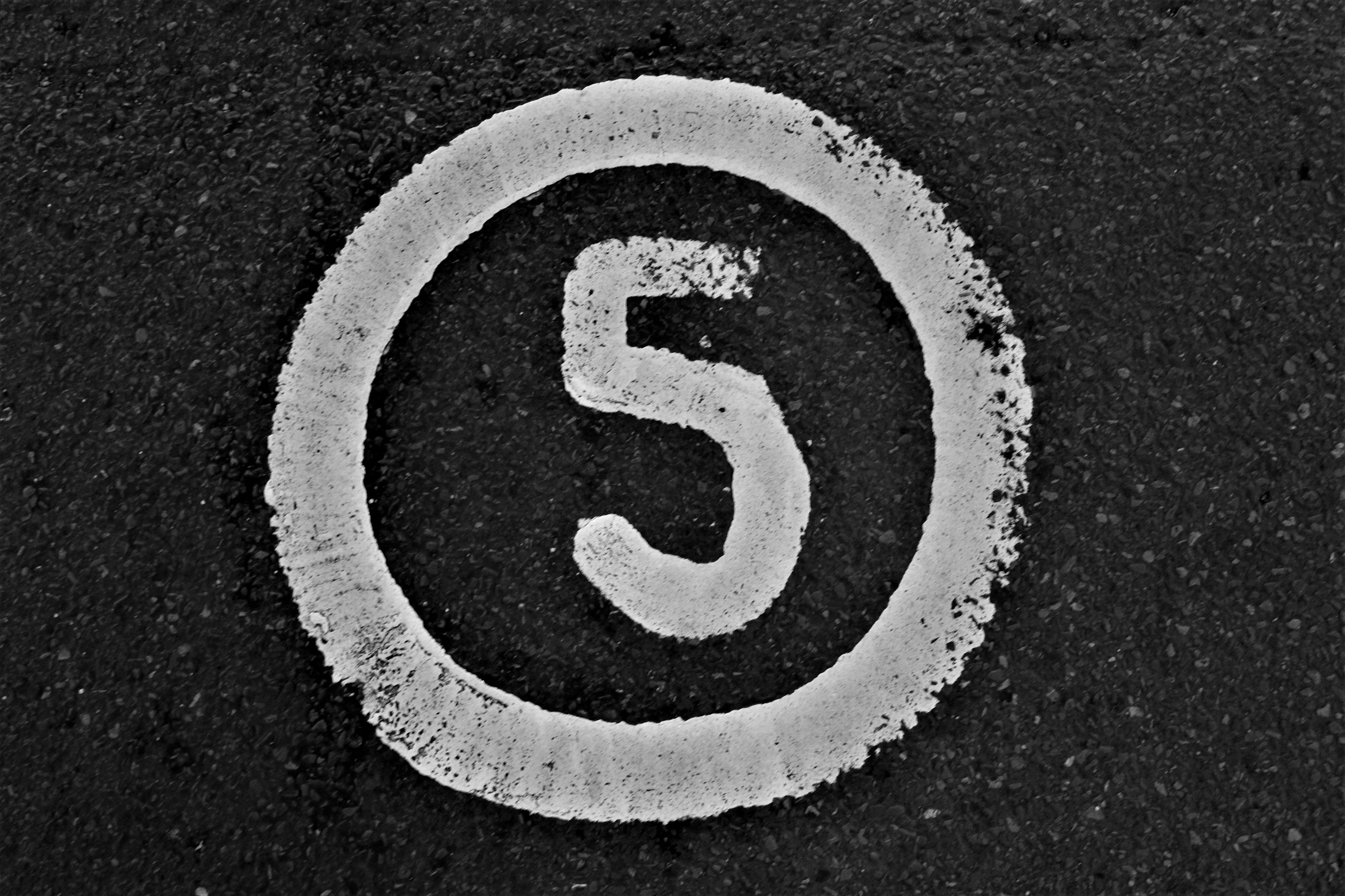 アスファルトに白く描かれた大きな数字「5」のクローズアップ