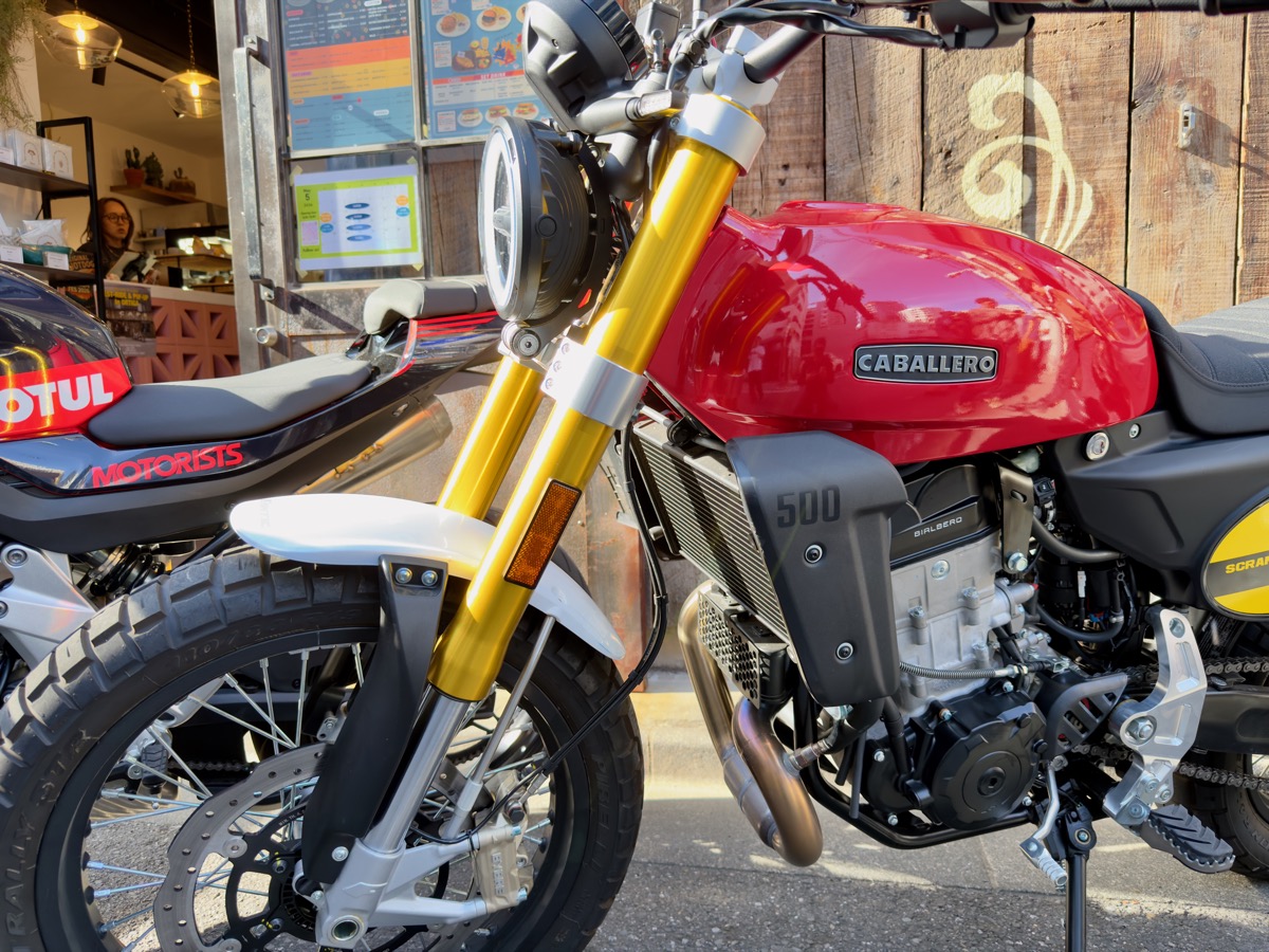 CABALLERO Scrambler 500のフロント周り。ゴールドの倒立フォーク、丸型ヘッドライト、赤いタンクにCABALLEROの刻印