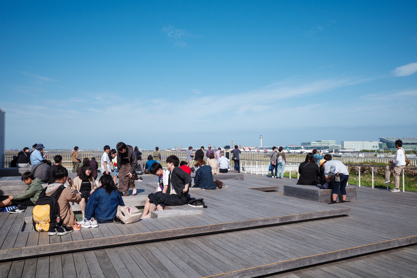 足湯スカイデッキから羽田空港を眺める人々