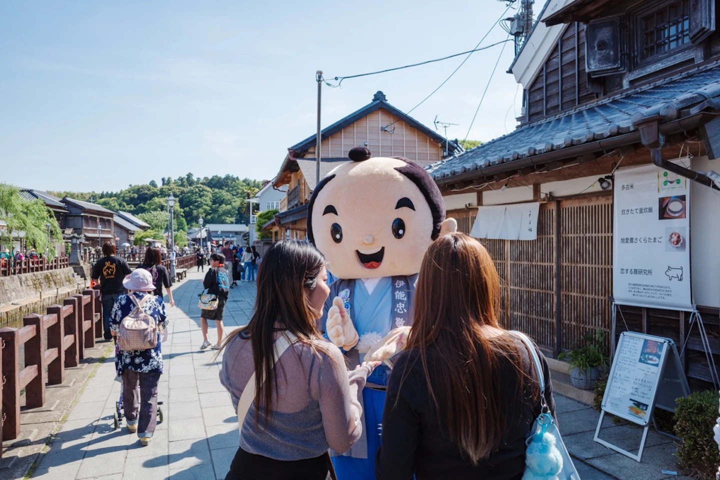 伊能忠敬のゆるキャラと記念撮影する観光客