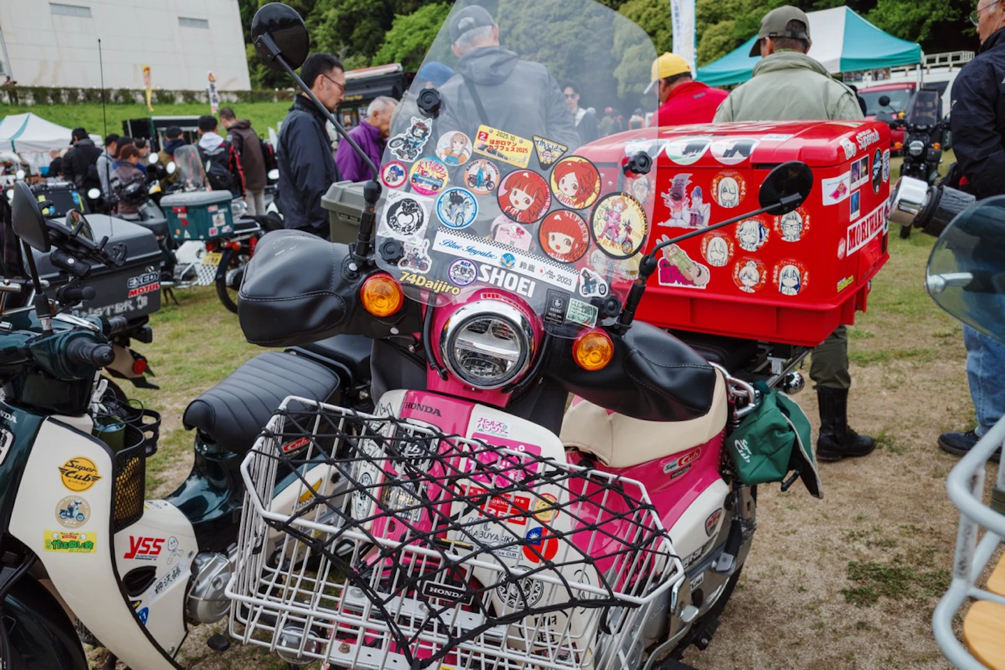 ステッカーとグッズで飾られたピンクのカブ