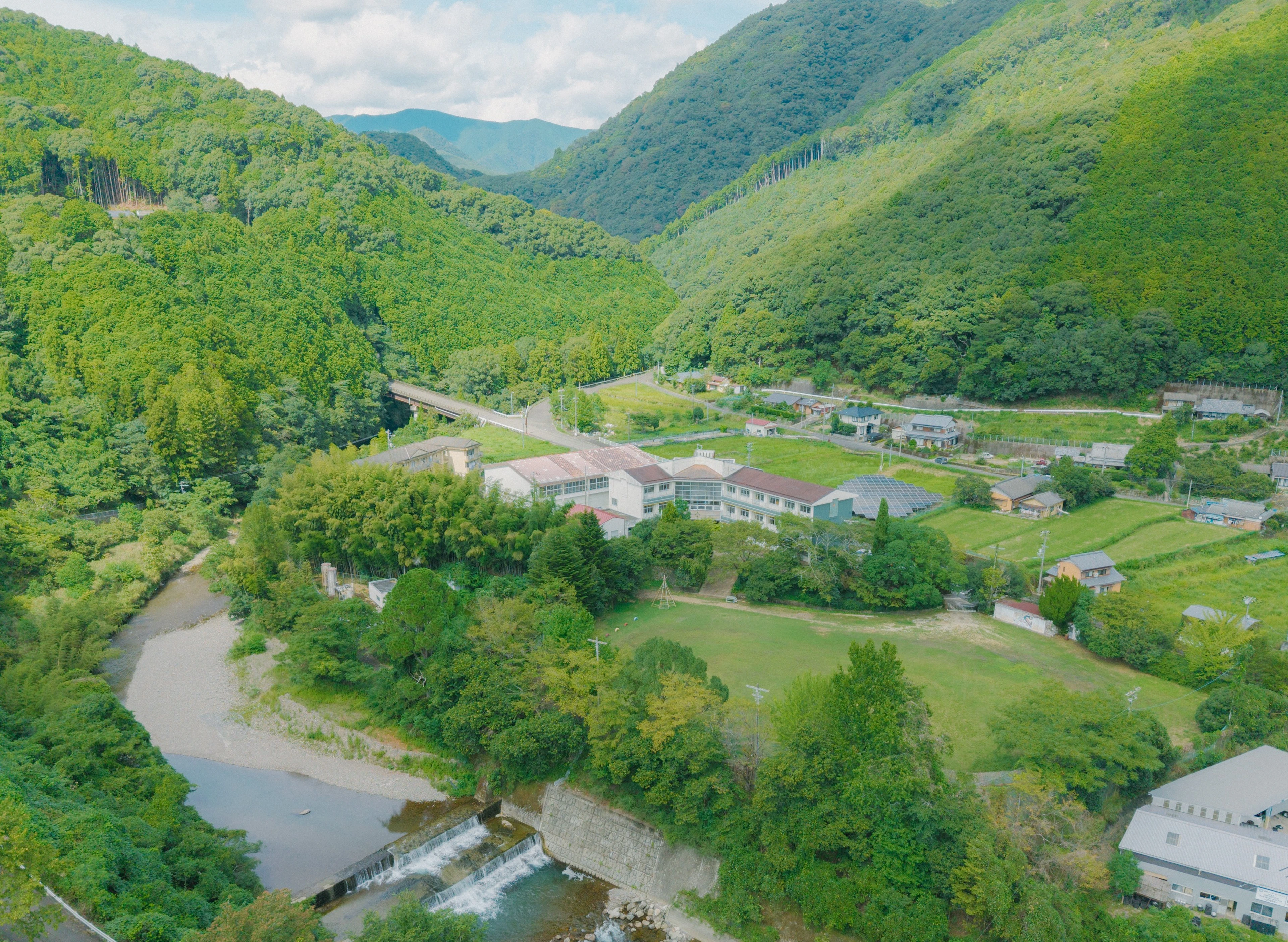 和歌山県田辺市の大自然と、その中に佇む「うつほの杜学園小学校」。構想段階から対話の場や困っていることを開示し、共創の機会を積極的にひらくことで、地域の人々と共に学校を創るというプロセスを実現させた。