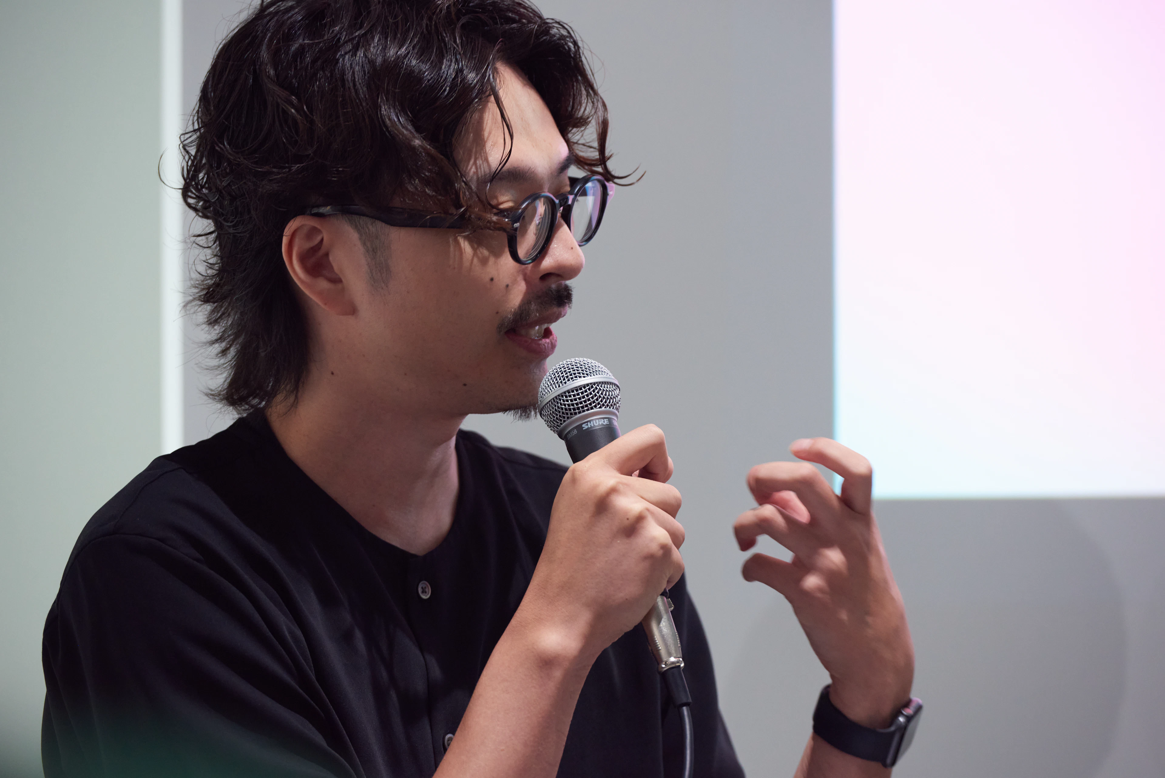 田中康寛さんが身振りを交えながらマイクで発言する様子