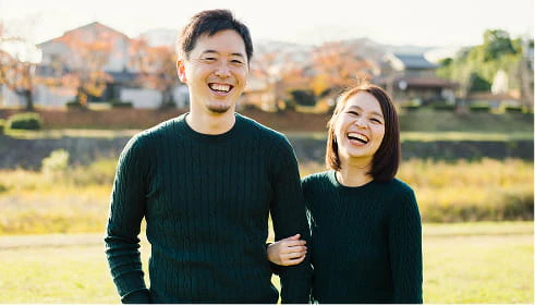 屋外で仲良く笑い合う男女のカップルのイメージ