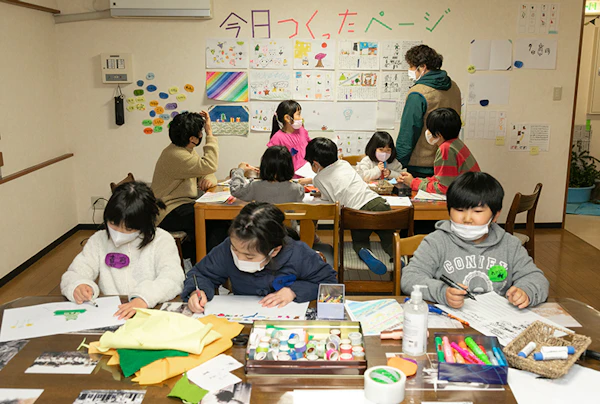 「今日つくったページ」の掲示のもと、机で制作する子どもたち