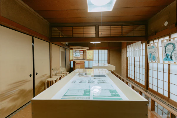 民家の座敷に設けられた展示台と、並べられた資料