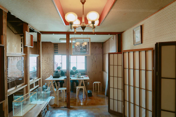 シャンデリアのある部屋の奥で作業する2人