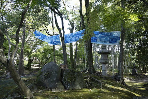 木立のあいだに張り渡された藍色の染め布の作品