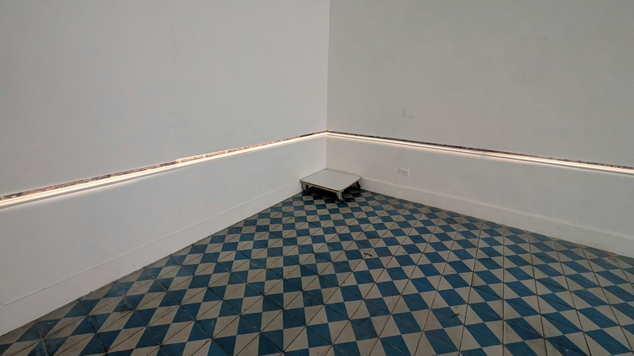 Ausstellungsansicht von „界行者“ bei 未命名. Das Licht entlang der Wand zeichnet eine weitere Kontur in den Raum.