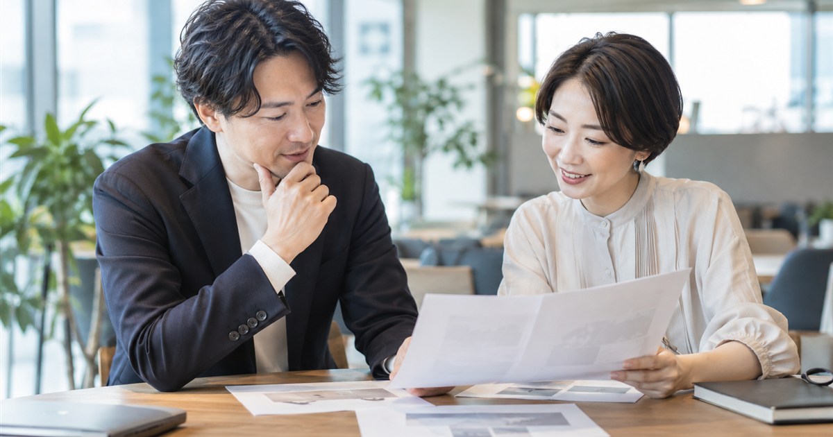 打ち合わせスペースで原稿を見ながら相談する担当者と編集者
