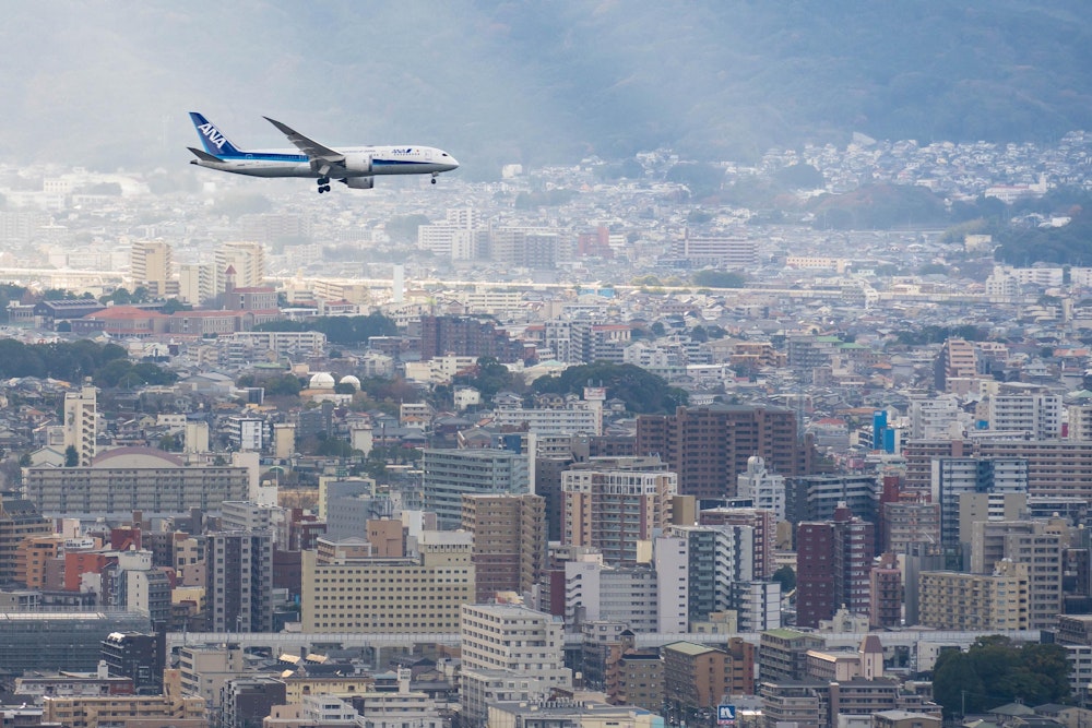 <p>ANA の機体だった。背後の都市風景との対比が非現実的だ。</p>