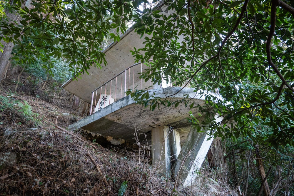 <p>上部まで来ると、突然コンクリート造の建造物が現れた。展望台だった。<br>ベンチが置かれていて、ひと休みできるようになっている。<br>山の中の急斜面のこの場所にこれを建てたのはなかなかの仕事だっただろう。</p>