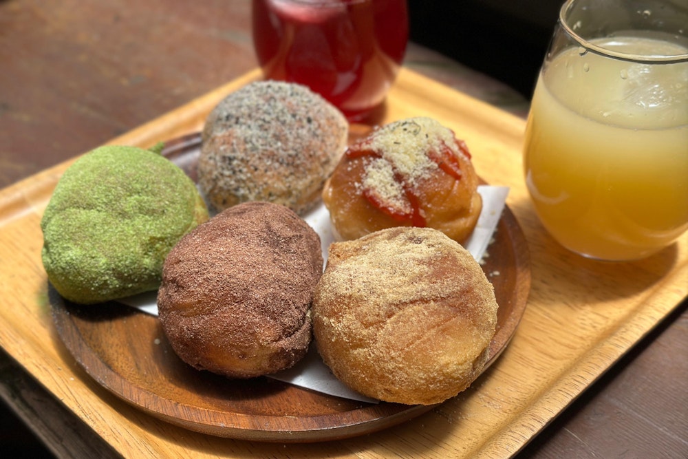 <p>そう、高見石小屋といえばこの揚げパンのセット。<br>もちろん期待はしていたが、その期待の上をいく美味しさに驚愕した。<br>揚げているので外はカリッとしてジューシー、中はふわっとしていてとても軽い口当たり。<br>2 人で分けたが、1 人で 5 個ずつ食べたいくらいだった。</p>