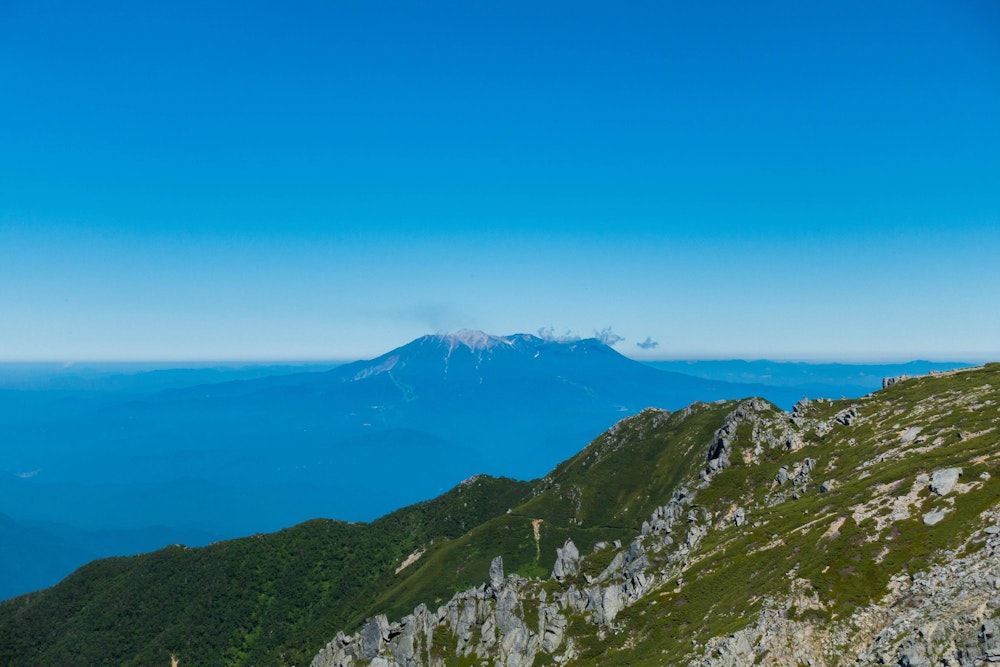 <p>前年の噴火が記憶に新しい御嶽山。<br>火山灰を被って白くなっている。</p>