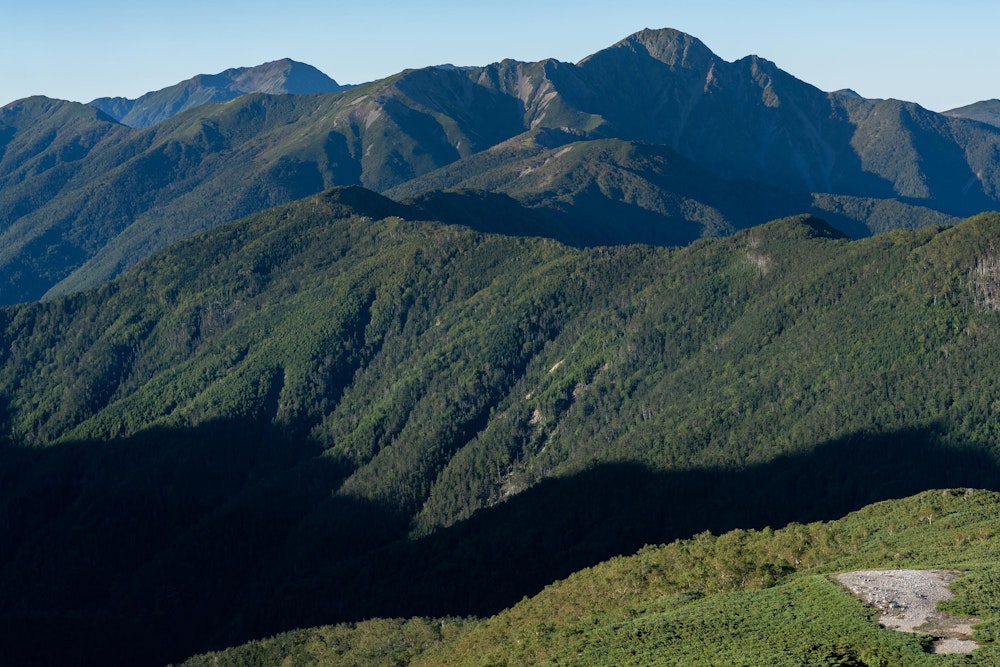 <p>左右に畝りながら伸びる仙塩尾根と、その先に見える塩見岳。<br>至福の稜線歩きだ。</p>