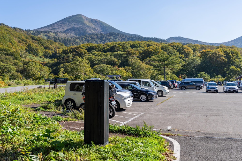 <p>前泊した八戸市中心街を 6:00 過ぎに出発し、9:00 前に酸ヶ湯公共駐車場に到着。<br>その頃には区画は埋まっていて、若干の路駐が発生している状況だったので、そこに続くように駐車。</p>