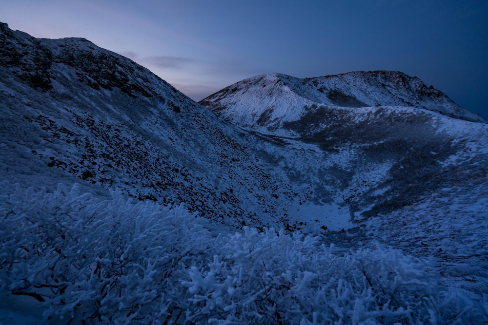 <p>夜明け前に登り初める。<br>東の空が白んでくると、白い風景が浮かび上がってきた。</p>