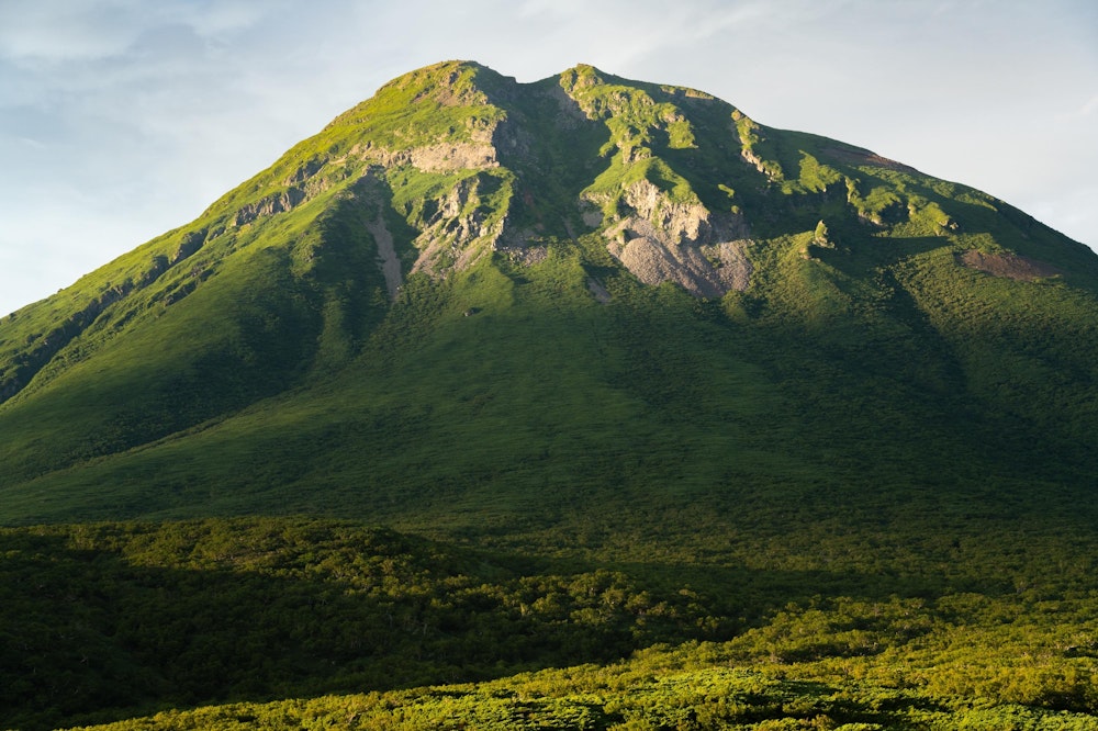 <p>知床五湖を楽しんだあと、車で夕暮れの知床峠へ。<br>夕日を浴びて浮かび上がる羅臼岳頂上の岩稜。</p>
