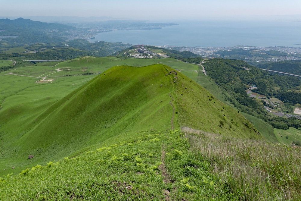 <p>ここだけ草原になっていて、異様な雰囲気。尾根上につけられた道を歩く。<br>不思議な気分になりつつも、この爽快な尾根を辿って下山する。<br>注意点としては、向かって左手側は自衛隊の演習場になっているため、立ち入らないことだ。</p>