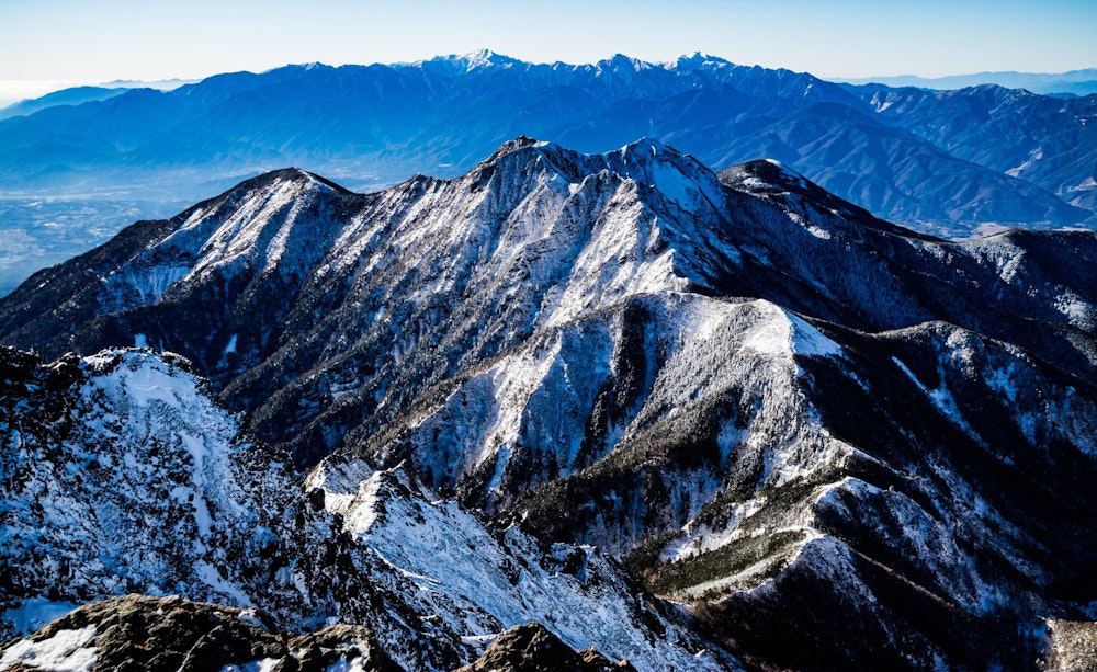 <p>権現岳と奥には南アルプスが見える。<br>冬山の現実離れしたような景色は圧巻だ。</p>