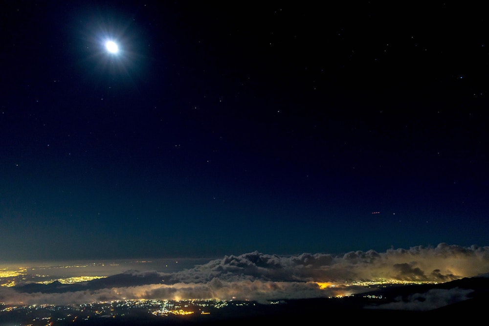 <p>月明かりに照らされ、ヘッドライトを使わなくても登山道が見えるくらい。<br>下界の夜景と、街を覆うように湧き立つ雲が美しい。</p>