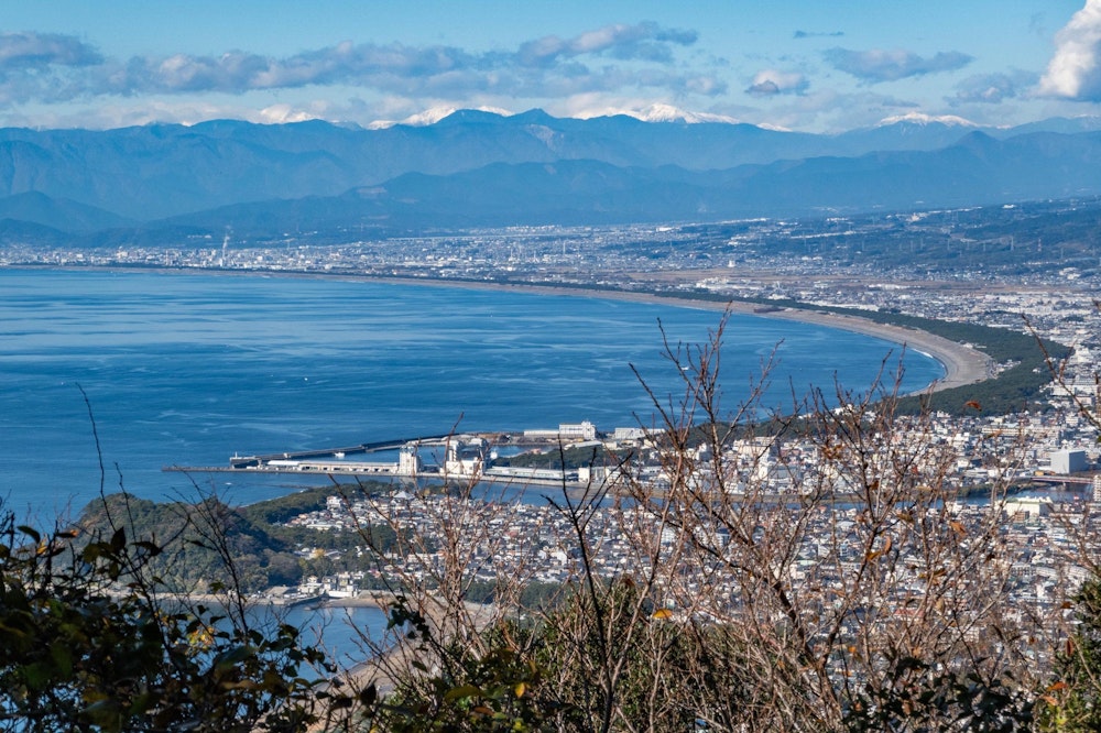 <p>駿河湾と、その奥には真っ白な雪をかぶった南アルプスの山並みが見える。<br>あの南アルプスもすっかり雪化粧か。</p>