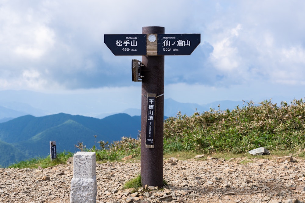 <p>そしてたどり着いた平標山頂上。多くの登山者で賑わっている。<br>10 年前から山頂標識は新しくなっていた。</p>