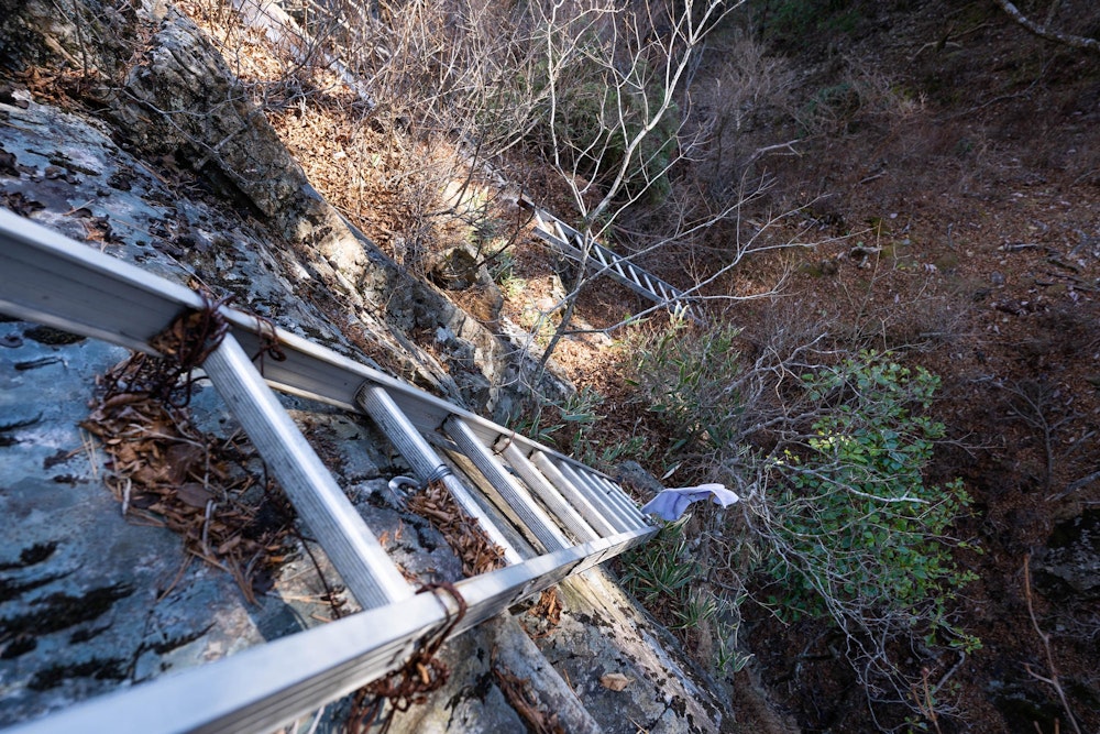 <p>垂直の岩に掛けられた二連ハシゴ。<br>緊張の連続だ。</p>