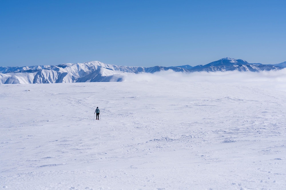 <p>山頂は異常なまでにだだっ広い空間が広がっていた。<br>向こうに広がる雲海と境目がわからなくなって、大平原のように見える。</p>