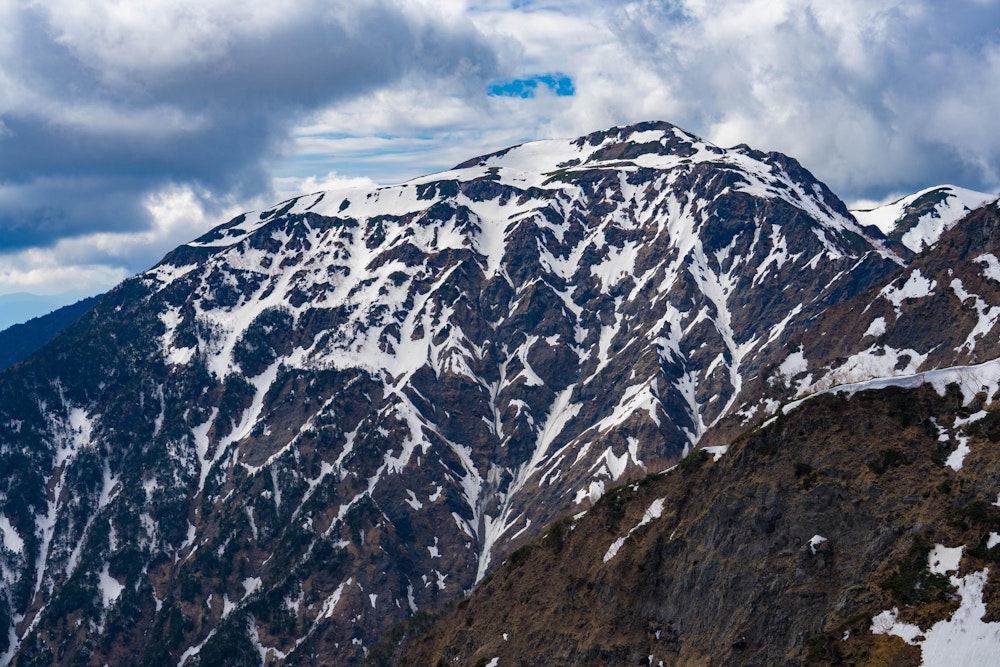<p>兎岳の雄姿。大きな岩壁についた複雑な模様の雪形が印象的だ。</p>