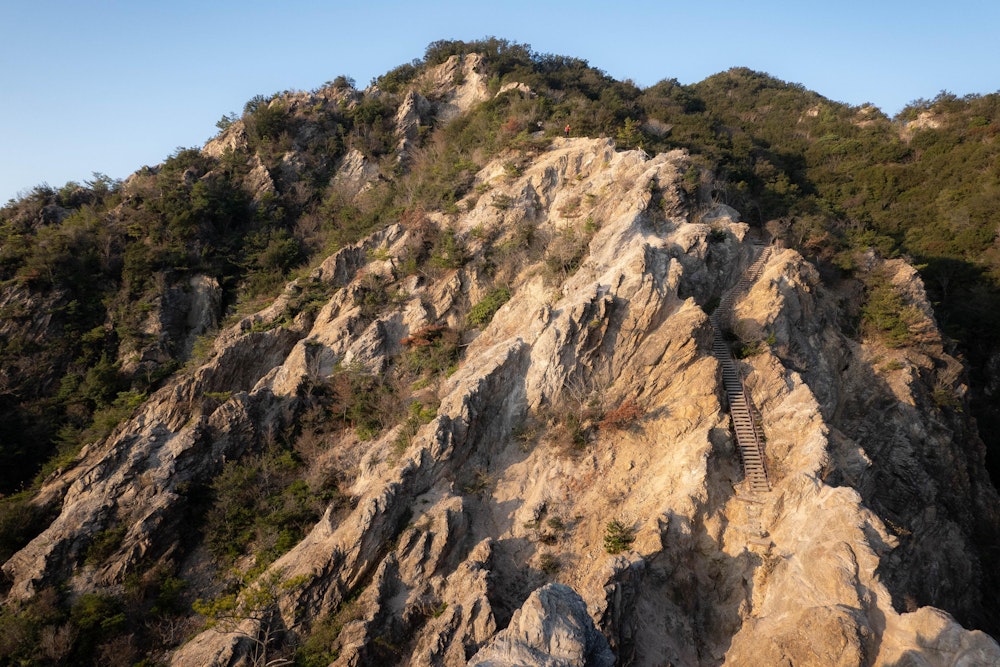 <p>六甲全山縦走でもっともシンボリックな風景かもしれない、須磨アルプス、名勝・馬の背。<br>標高も300m程度で住宅街にもほど近いにもかかわらず、この場所だけがこのように一枚岩の露出した地形になっており不思議。<br>ゆっくり歩けば危険な場所はないが、気を抜くと滑るかもしれないので注意。</p>