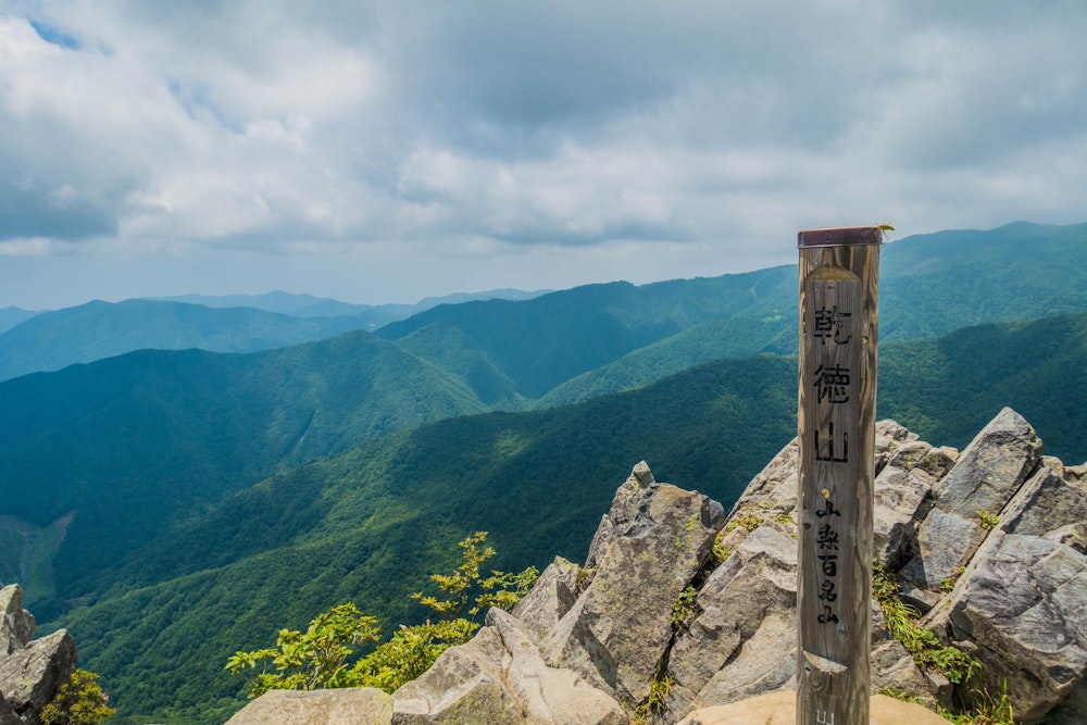 <p>乾徳山に登頂。<br>岩場の間を縫うように休憩できる場所が点在した狭い山頂。<br>景色は 360 度の大展望。</p>
